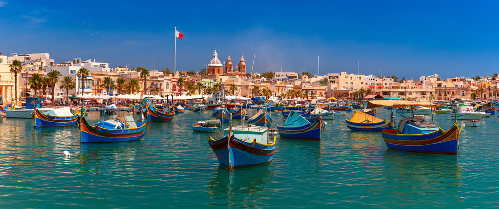 Tradiční barevné lodě s okem v malebné rybářské vesnici Marsaxlokk, Malta